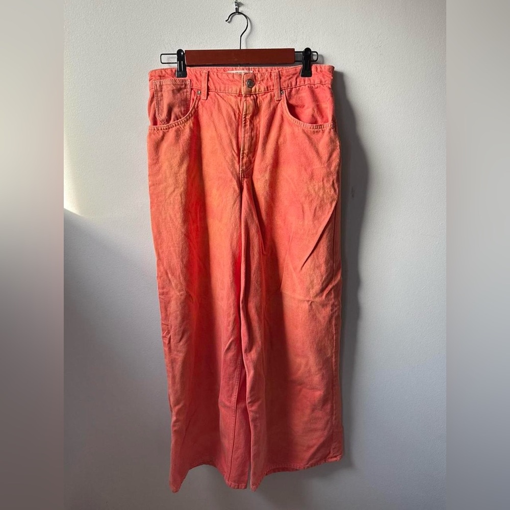 Vintage-style We The Free wide-leg pants in a faded coral/pink wash.